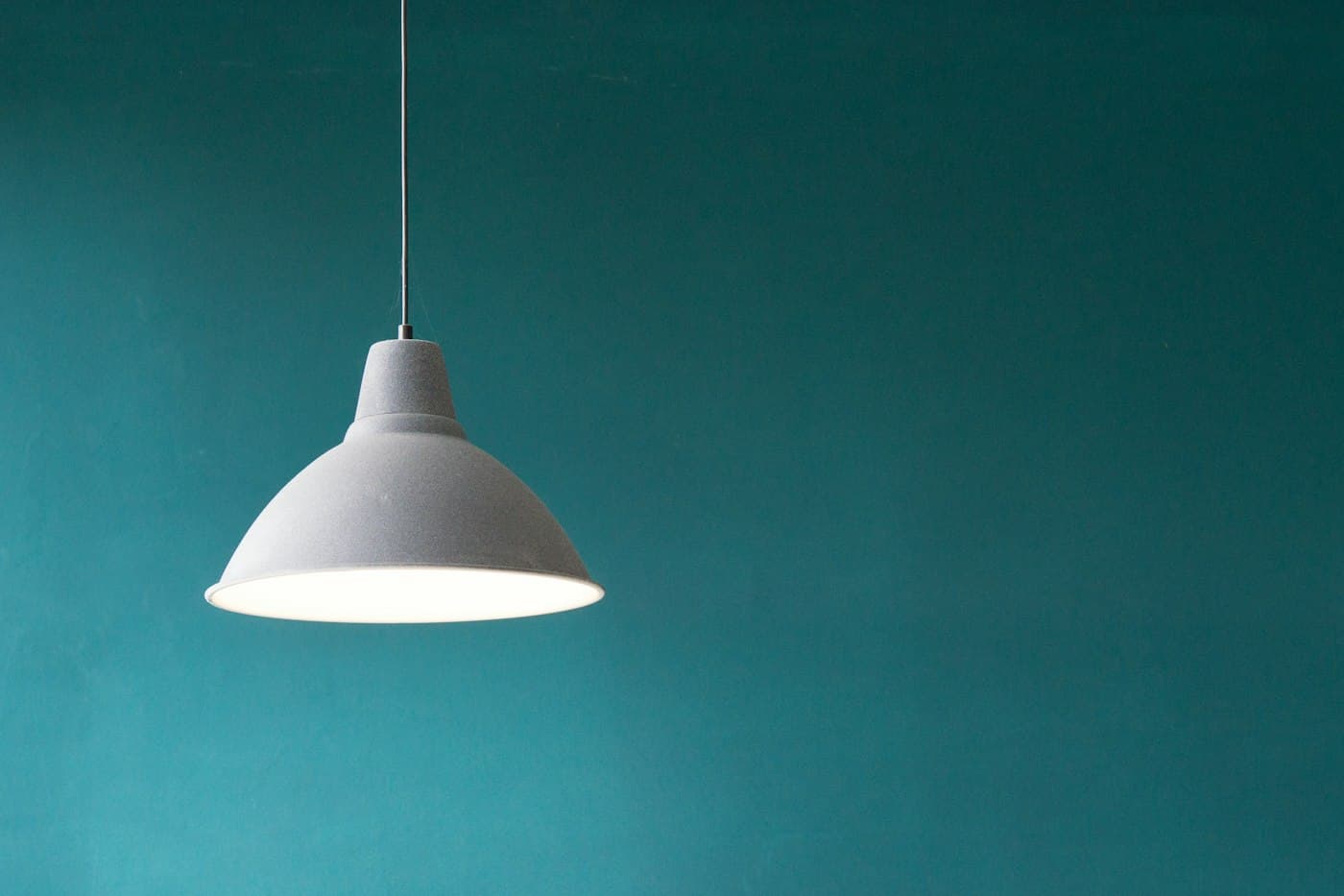 Suspension Halo blanche sur mur bleu-vert